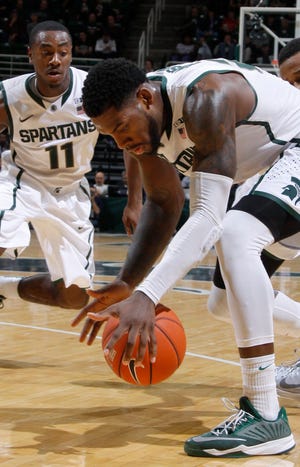 Michigan State's Branden Dawson, center, gets a steal against Oakland's Nick Daniels, right, during the first half of an NCAA college basketball game, Sunday, Dec. 14, 2014, in East Lansing, Mich. At left is Michigan State's Lourawls Nairn Jr. (AP Photo/Al Goldis)