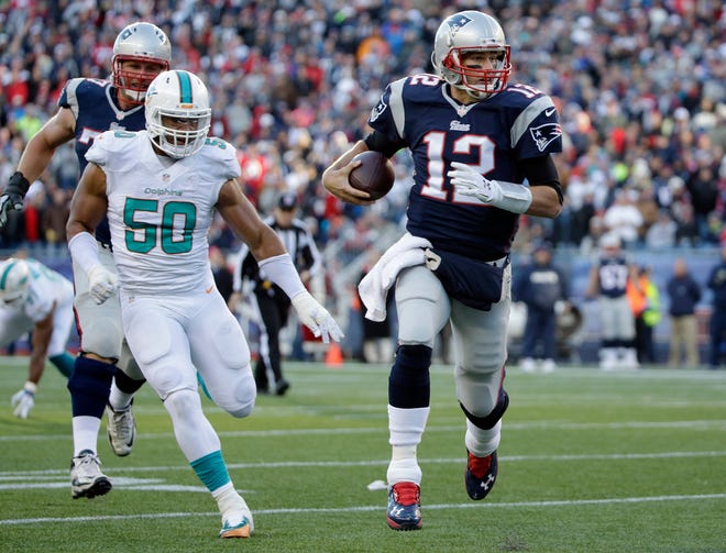 New England Patriots quarterback Tom Brady (12) runs with the ball as Miami Dolphins defensive end Olivier Vernon (50) gives chase during their game in Foxborough, Mass., on Sunday. Photo by AP.