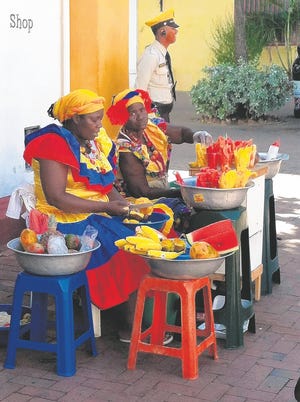 Colorfully dressed vendors sell fruit in the old city of Cartagena, 
Colombia.AP PHOTO/BETH J. HARPAZ/2013