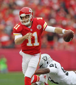 Kansas City Chiefs quarterback Alex Smith runs past a tackle attempt by Oakland Raiders defensive end Justin Tuck during Sunday's game at Arrowhead Stadium.