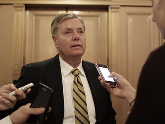 Sen. Lindsey Graham (R-SC) talks with reporters after the Senate voted on a $1.1 trillion spending bill to fund the government through the next fiscal year on Saturday, Dec. 13, 2014 on Capitol Hill in Washington. (AP Photo/Lauren Victoria Burke)