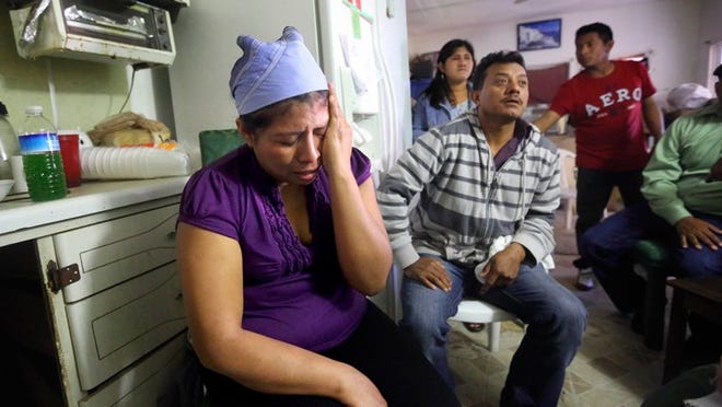 A grieving Eva Perez, (L), and her husband Gilberto Sanchez, (2L), speak about the car accident that claim the life of their one year and five month old son Gilberto Aaron Sanchez, Saturday afternoon just outside their modest trailer home in the Holiday II Trailer Park Dec 14, 2014, in Lake Worth. ( Bill Ingram / Palm Beach Post)