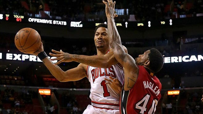 Derrick Rose (1) passes around Miami's Udonis Haslem during the Bulls' 93-75 rout of the Heat on Sunday. (Getty Images)