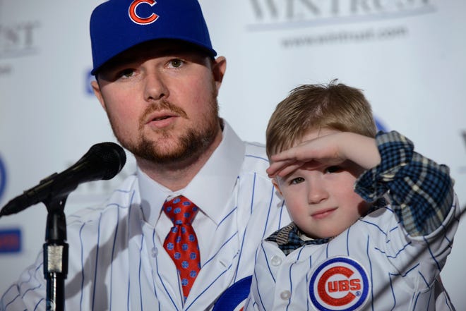 Pitcher Jon Lester speaks to the media as his son Hudson, 4, looks on after Lester was introduced as a member of the Chicago Cubs during a press conference in Chicago, Monday, Dec. 15, 2014. (AP Photo/Paul Beaty)