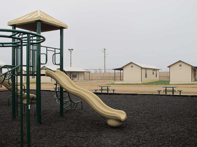 A playground surrounded by cottages that will house immigrants at a new family immigration detention center in Dilley, Texas, on Monday, Dec. 15, 2014. Opening following a summer surge of children crossing the U.S.-Mexico border illegally, the compound features cottages and will have an initial capacity of 480 growing to 2,400 around May _making it the nation's largest family immigration lockup. (AP Photo/Will Weissert)
