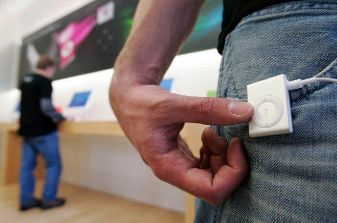 FILE - In this Nov. 3, 2006 file photo, a man wears an Apple iPod Shuffle at an Apple store in Palo Alto, Calif. After just a few hours of deliberation, a jury in California on Tuesday, Dec. 16, 2014 found in favor of Apple in a billion-dollar class-action lawsuit over the price of its iPod music players. (AP Photo/Paul Sakuma, File)