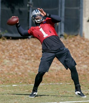 Carolina Panthers quarterback Cam Newton prepares to throw a pass during an NFL football practice in Charlotte, N.C., Wednesday, Dec. 17, 2014. (AP Photo/Chuck Burton)