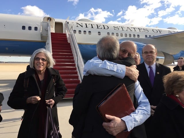 THE ASSOCIATED PRESS / In this handout photo provided by Jill Zuckman, Alan Gross, facing camera, is hugged by Tim Rieser, an aide to Sen. Patrick Leahy, D-Vt., Wednesday, Dec. 17, 2014, at Andrews Air Force Base, Md., upon his arrival from Cuba. Gross's wife Judy is at left, Rep. Jim McGovern, D-Mass. is at right. (AP Photo/Jill Zuckman)