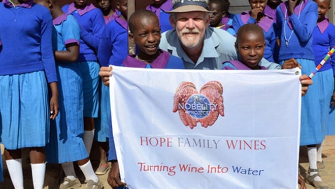 Turk Pipkin, director and founder of The Nobelity Project, poses with students of Enkongu Narok Primary in Kenya. Pipkin’s nonprofit brought water to the school.