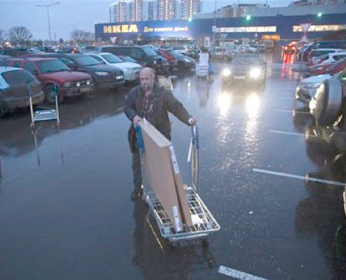 A man pushes a cart with purchases to his car Wednesday, Dec. 17, 2014, at an IKEA store on the outskirts of Moscow, Russia. The collapse of the national currency triggered a spending spree by Russians desperate to buy cars and home appliances before prices shoot higher. Several car dealership were reported to have suspended sales, unsure how far down the ruble will go, while Apple halted all online sales in Russia.