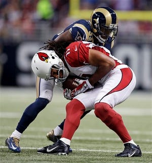 Arizona Cardinals' Larry Fitzgerald (11) is tackled by St. Louis Rams' E.J. Gaines during the first half of an NFL football game Thursday, Dec. 11, 2014 in St. Louis. (AP Photo/Jeff Roberson)