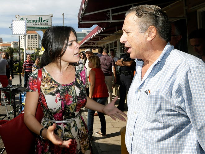 Cuban-American and pro-Obama supporter Claudia Hernandez, left, argues with anti-Castro protester Daniel Tarrab, right, in the Little Havana area of Miami, Thursday, Dec. 18, 2014.