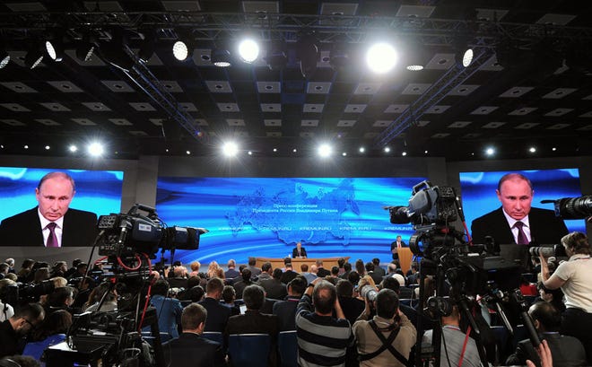 Russian President Vladimir Putin, center, speaks during his annual news conference in Moscow, Russia, Thursday, Dec. 18, 2014.