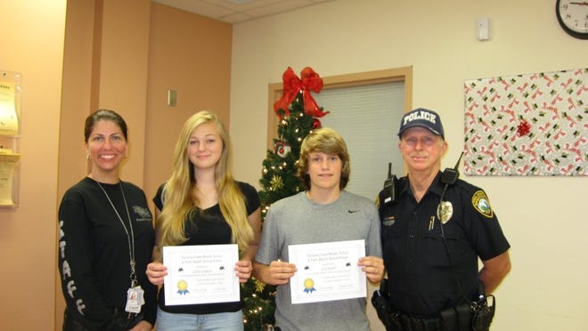 Caitlin Simpson and Seth Howell, flanked by Principal Nicole Daly and Officer Sandy Molenda, were named Osceola Creek Middle School Scholar-Athletes for November.
