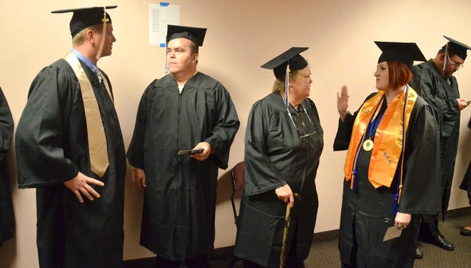 PETER.WILLOTT@STAUGUSTINE.COM St. Augustine residents and St. Johns River State College students Kevin Kopin, Steven Brown, Gloria Ellithorpe and Vanessa Roth talk in a hallway of the Thrasher-Horne Center for the Arts on the state college's Orange Park campus before the start of fall commencement on Thursday, Dec. 18, 2014.