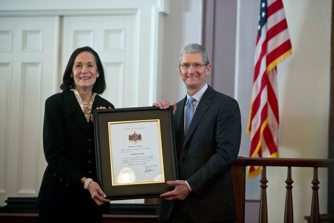 Apple chief executive and Alabama native Tim Cook, right, and Catherine Randall pose with a plaque during an Alabama Academy of Honor ceremony at the state Capitol Monday, Oct. 27, 2014, in Montgomery, Ala. Cook and seven others, including Alabama football head coach Nick Saban, were inducted into the Alabama Academy of Honor. (AP Photo/Brynn Anderson)