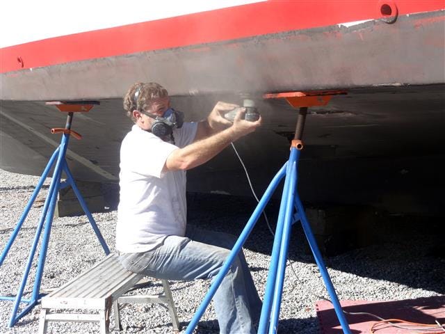 Capt. Mike Eller of the Lady Em sands the bottom of his boat Monday afternoon.