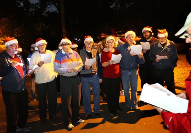Neighbors and the Barbergators sing Christmas carols in the Raintree subdivision in Gainesville on Dec. 14.