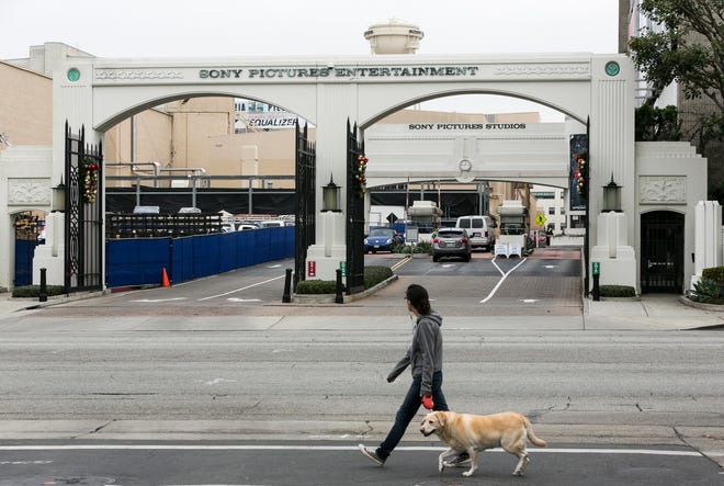 In this Thursday, Dec. 18, 2014 file photo, a local resident walks her dog by the gates of Sony Pictures Entertainment Studios on Overland Avenue in Culver City, Calif. Suspicions that North Korea was behind a destructive hacking attack against Sony Pictures and a threat against movie theaters are intensifying calls for tougher U.S. steps to cut that country?s access to hard currency and declare it once more as a state sponsor of terrorism.