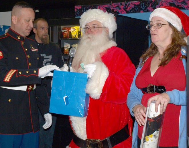 Marine Reserves Cpl. Steve Martinez, representing Toys for Tots, left; Santa "Ugly George," center; and Our Everyday Angels founder Maria Herb call out numbers for door prizes at the organization's annual Children's Christmas Party held at Walden Lanes. DONNA KESSLER/Times Herald-Record