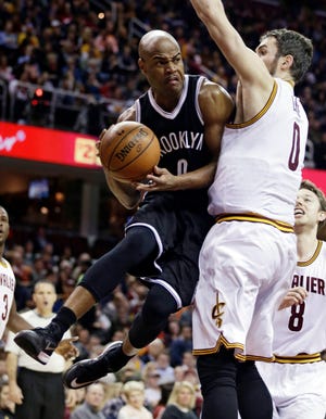 Nets' Jarrett Jack, left, is defended by Cavaliers' Kevin Love as he looks to pass during the second quarter of Friday night's game in Cleveland. The Associated Press
