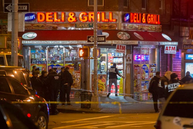 Investigators work in the area where two NYPD officers were shot in the Bedford-Stuyvesant neighborhood of the Brooklyn on Saturday. Police said an armed man walked up to two officers sitting inside a patrol car and opened fire before running into a nearby subway station and committing suicide. Both police officers were killed.