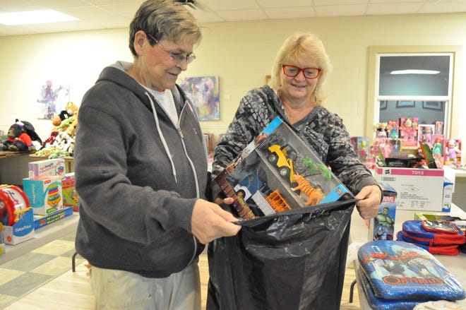 Santa's elves, Debbie Jackson (left) and Gail Hubler pack a Christmas gift bag Dec. 17 at United Church of Christ in New Smyrna Beach for the Gifts of Love Christmas Toy Drive.