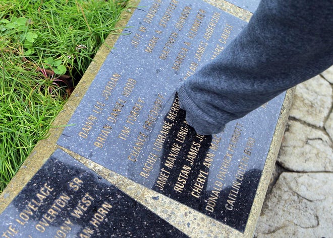 Jacob Gonzalez touches the name of his girlfriend, Rachel Lorraine Merrell, etched on one of the plagues at the MADD Memorial Garden in Eugene.  (Paul Carter/The Register-Guard)