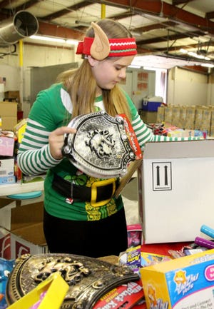 Jamie Mitchell • Times Record - Dressed as a Christmas elf, Gracie Kuhns fills boxes with toys Saturday, Dec. 20, 2014, for the annual holiday package distribution at the Community Services Clearing House. Volunteers gathered to fill the holiday requests for 300 personal packages of food, clothing and toys made by families in the area. Gracie is the 12-year-old daughter of Tami and Jeff Kuhns of Pocola. 
 Jamie Mitchell • Times Record - Dressed as a Christmas elf, Gracie Kuhns fills boxes with toys Saturday, Dec. 20, 2014, for the annual holiday package distribution at the Community Services Clearing House. Volunteers gathered to fill the holiday requests for 300 personal packages of food, clothing and toys made by families in the area. Gracie is the 12-year-old daughter of Tami and Jeff Kuhns of Pocola.