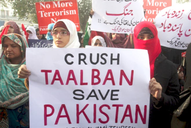 Pakistanis hold up posters to condemn Tuesday’s Taliban attack that killed more than 130 children at a school in Peshawar, as they take part in a rally Sunday in Lahore, Pakistan.