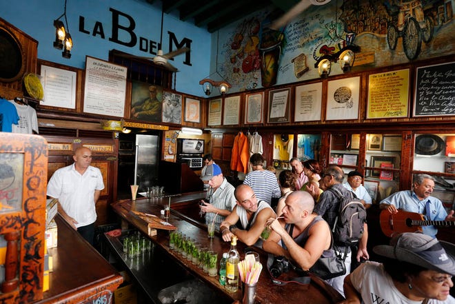 In this Dec. 19, 2014 photo, tourists fill the famous La Bodeguita del Medio bar where U.S. author Ernest Hemingway used to drink in Old Havana, Cuba.