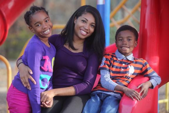 Shamanda Burston poses for a photo with her two children Zaima Williams, 6, left, and Navor Williams, 7. Recently Burston graduated from Gardner-Webb University with her master's degree. (Ben Earp/The Star)