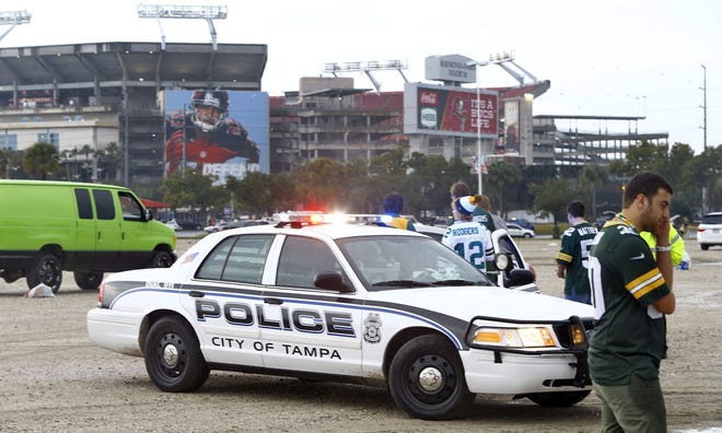 Tampa Police Officers talk to spectators after football fans were reportedly taken to the hospital with injuries after a lightning strike near the Raymond James Stadium, Sunday, Dec. 21, 2014, in Tampa, Fla.