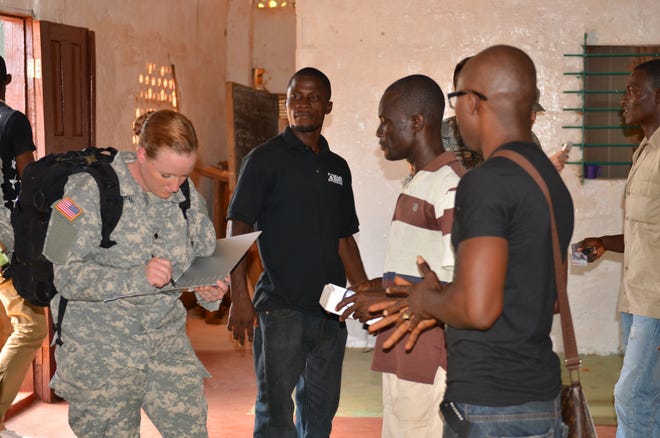 Addison Amaral, left, a Gainesville native and a combat medical specialist of the 82nd Civil Affairs Battalion, 85th Civil Affairs Brigade, talks to members of the local community near the National Police Training Academy in Paynesville, Liberia, on Nov. 29.