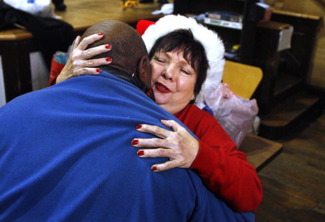 Lynn Loveday hugs a homeless man at Harrington Hall.