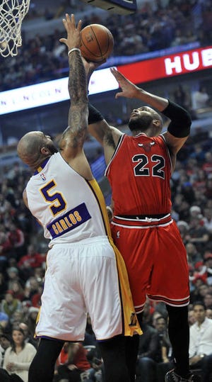 Chicago Bulls' Taj Gibson (22) shoots against the defensive efforts of Los Angeles Lakers' Carlos Boozer during their NBA game Thursday night in Chicago. The Bulls won, 113-93.