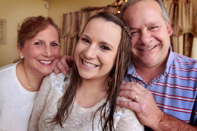 Sara Powell with her parents, Robin and Christopher Powell, at the family’s home in Middletown on Tuesday.