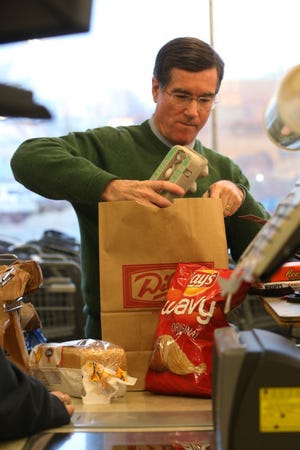 Retiring Kroger CEO Dave Dillon bags groceries for customers at the 14th Ave. Dillons Tuesday, Dec. 23, 2014.