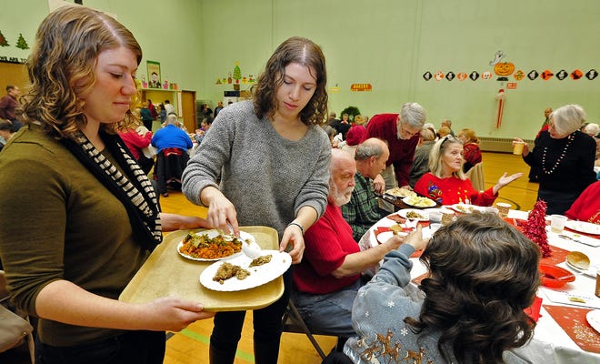Sisters Rebecca and Rachel Bier serve food during the Jewish Federation of Greater New Bedford's annual Christmas dinner Thursday. DAVID W. OLIVEIRA/STANDARD-TIMES SPECIAL