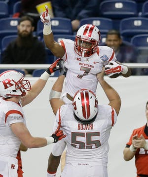 Rutgers running back Robert Martin is lifted by offensive lineman Betim Bujari after his touchdown Friday during the second half of the Quick Lane Bowl against North Carolina in Detroit. THE ASSOCIATED PRESS