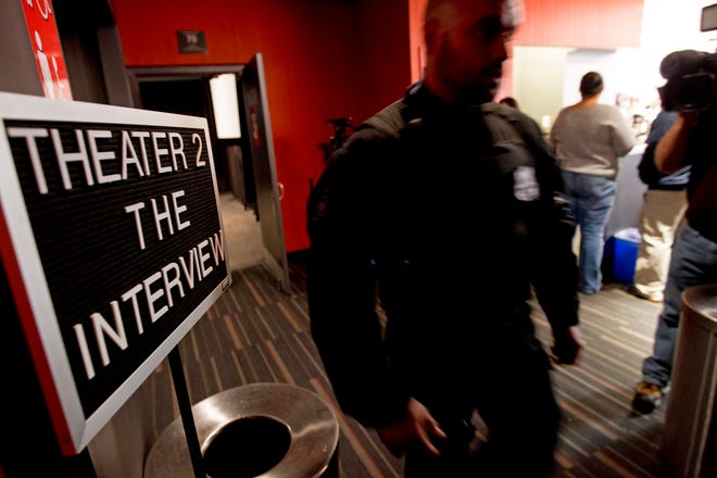 A police officer keeps watch as moviegoers enter the theater to watch The Interview at West End Cinema in Washington, Thursday, Dec. 25, 2014. Hundreds of theaters Thursday, from The Edge 8 in Greenville, Alabama, to Michael Moore's Bijou by the Bay in Traverse City, Michigan, made special holiday arrangements for the Seth Rogen-James Franco comedy depicting the assassination of North Korean leader Kim Jong Un. Sony Pictures had initially called off the release after major theater chains dropped the movie that was to have opened on as many as 3,000 screens. (AP Photo/Jose Luis Magana)