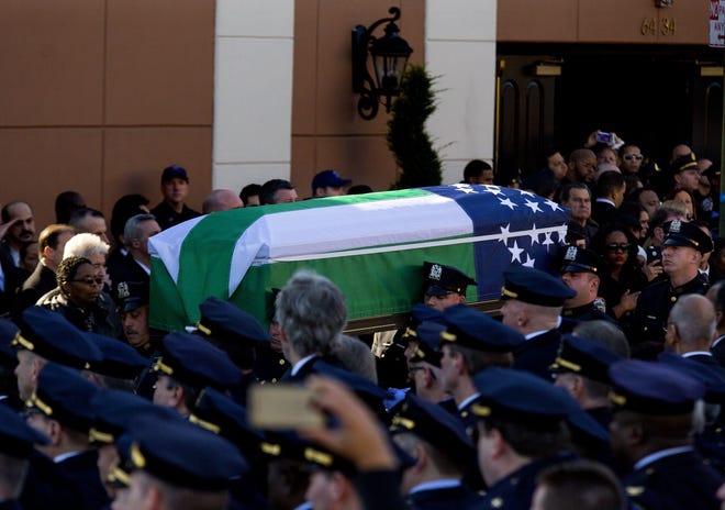 The body of New York City police officer Rafael Ramos is brought from Christ Tabernacle Church after his funeral in the Glendale section of Queens, where he was a church member, Saturday, Dec. 27, 2014, in New York. Ramos and his partner, officer Wenjian Liu, were killed Dec. 20 as they sat in their patrol car on a Brooklyn street. The shooter, Ismaaiyl Brinsley, later killed himself.
