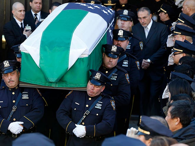 Pallbearers carry the casket of New York City police officer Rafael Ramos following funeral services at Christ Tabernacle Church, in the Glendale section of Queens, Saturday, Dec. 27, 2014, in New York. Ramos and his partner, officer Wenjian Liu, were killed Dec. 20 as they sat in their patrol car on a Brooklyn street. The shooter, Ismaaiyl Brinsley, later killed himself. (AP Photo/Julio Cortez)