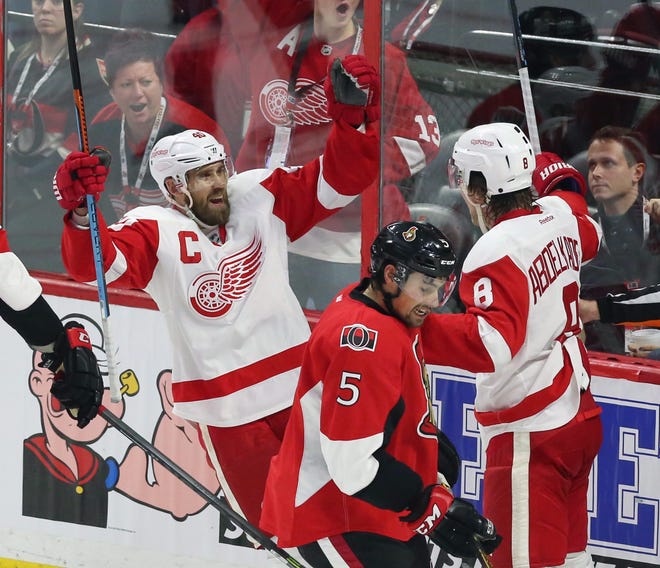 Detroit Red Wings' Justin Abdelkader (8) celebrates his goal with teammate Henrik Zetterberg (40) as Ottawa Senators' Cody Ceci (5) skates past during the first period of an NHL hockey game Saturday, Dec. 27, 2014, in Ottawa, Ontario. (AP Photo/The Canadian Press, Fred Chartrand)