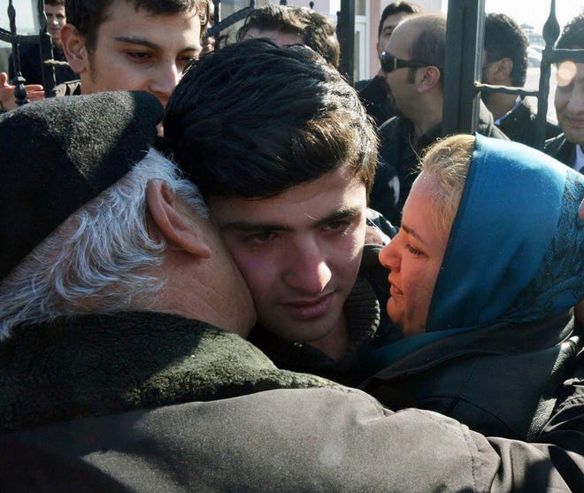 A Turkish teenager is embraced by his parents after his release from jail 
Friday in Konya, Turkey.AP PHOTO