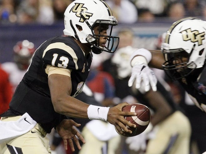 Central Florida quarterback Justin Holman (13) fakes a pass during the second quarter of the St. Petersburg Bowl NCAA college football game against North Carolina State in St. Petersburg, Friday, Dec. 26, 2014. (AP Photo/The Tampa Bay Times, Monica Herndon)