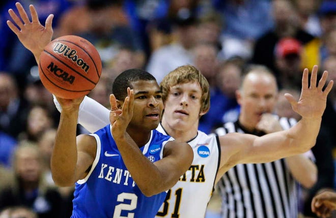 Kentucky guard Aaron Harrison passes as Wichita State guard Ron Baker defends during the first half of their NCAA Tournament contest on March 23, 2014 in St. Louis. Kentucky defeated Wichita State, 78-76.