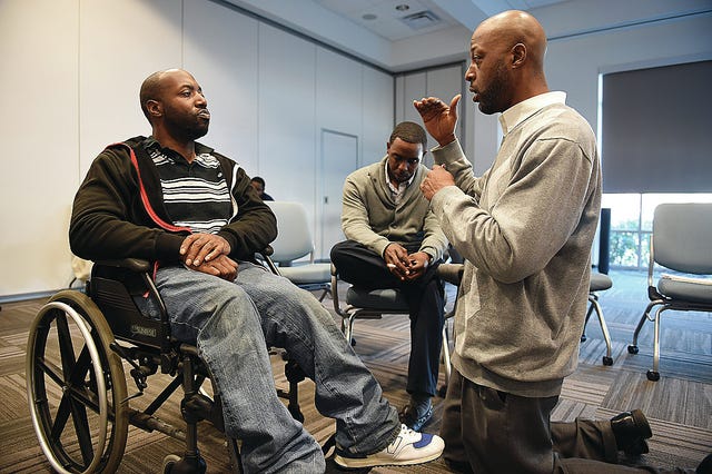 Kelvin Cook, left, speaks with Shawn Parris, an in-reach specialist with Cardinal Innovations Healthcare Solutions, right, as fellow in reach specialist, Anthony Nelson, center, looks on during a training session at Cardinal Innovations Healthcare Solutions on Wednesday December 17, 2014 in Kannapolis, North Carolina. Kelvin is part of the Transitions to Community Living Initiative. The program gives him the opportunity to leave the facility he was living in and move into his own apartment. Illustrates INDEPENDENCE (category a), by Stephanie McCrummen (c) 2014, The Washington Post. Moved Saturday, Dec. 27, 2014. (MUST CREDIT: Washington Post photo by Matt McClain)