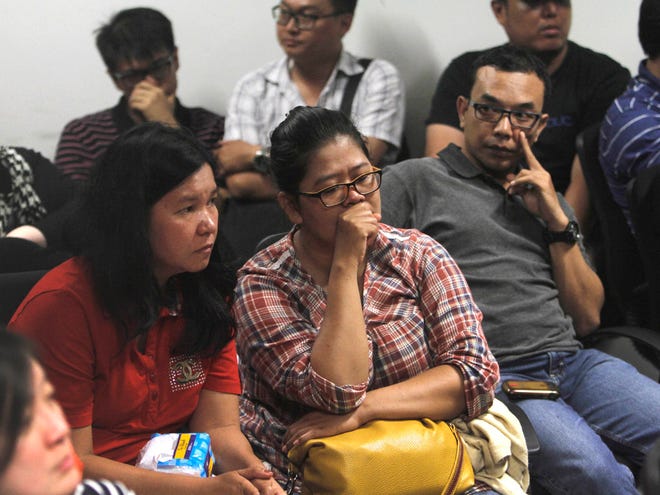 Relatives of the passengers of AirAsia flight QZ8015 wait for the latest news on the search of the missing jetliner at Juanda International Airport in Surabaya, East Java, Indonesia, Sunday, Dec. 28, 2014. A massive sea search was underway for the AirAsia plane that disappeared Sunday while flying from Indonesia to Singapore through airspace possibly thick with dense storm clouds, strong winds and lightning, officials said.