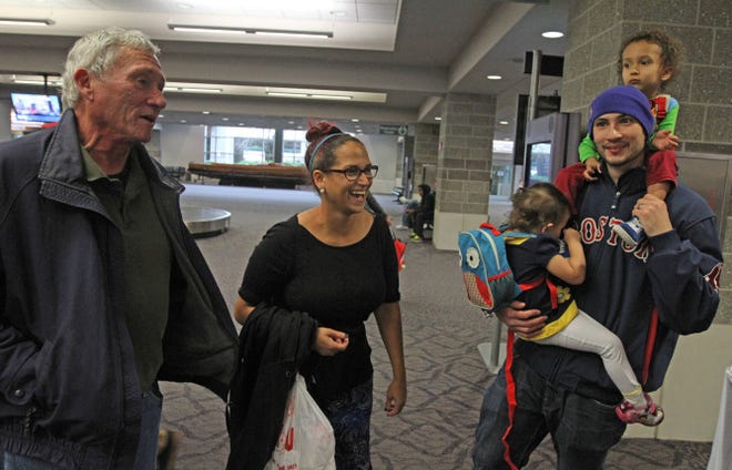 Juanita and Jeffrey Knight, of Miami Lakes, Fla.,with their children Cassius, 3, and Harmony, 2, are greeted by Jeffrey's father, Joe Knight, left, of Westerly, upon their arrival Sunday at T.F. Green Airport.